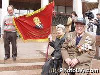 Митингующие пенсионеры с красным флагом на празднике Первомая в Киеве